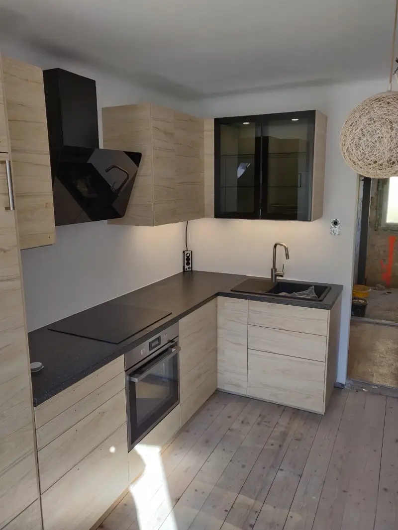 Svijetla drvena L-kuhinja s tamnom radnom pločom i modernom crnom napom - kuhinje po mjeri Zagreb