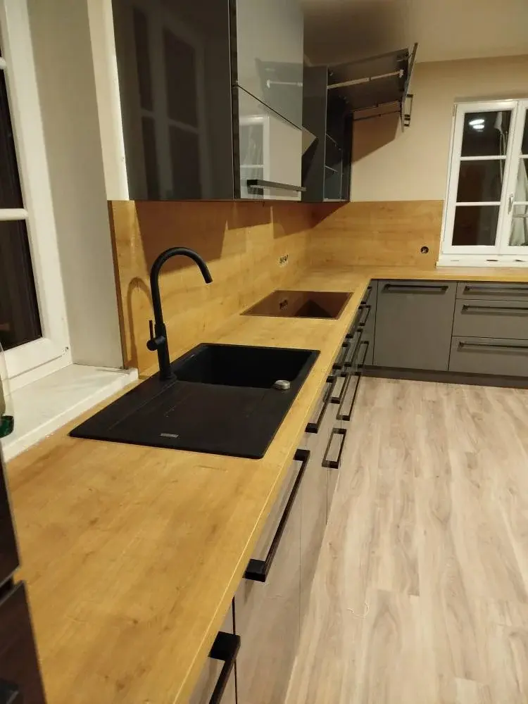 Siva kuhinja s drvenom radnom pločom i crnim sudoperom - montaža kuhinja Zagreb